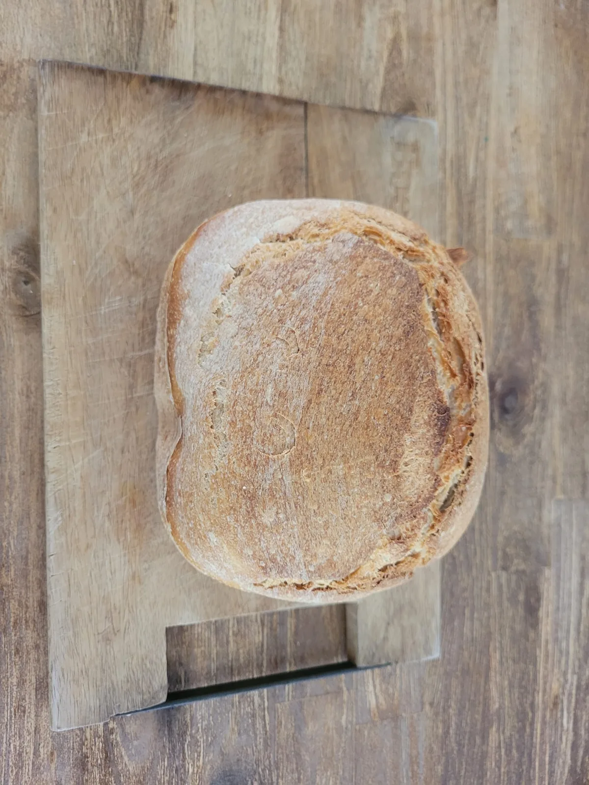 Bovenkant van een zuurdesembrood uit de Fornello broodbakmachine op een houten plank